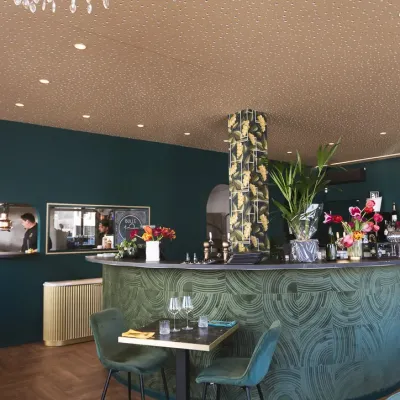Le bar en marbre vert et le lustre en cristal de la salle