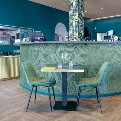Le bar habillé d'un motif marbre vert, au fond de la salle