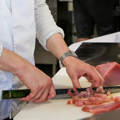 Le chef découpe un pavé de thon rouge en cuisine