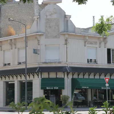 La façade de l'immeuble de 1924 vue depuis la place fleurie