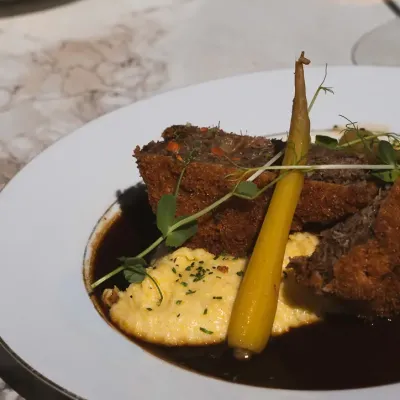 Plat du chef : viande croustillante, polenta crémeuse, carotte fane et jus corsé