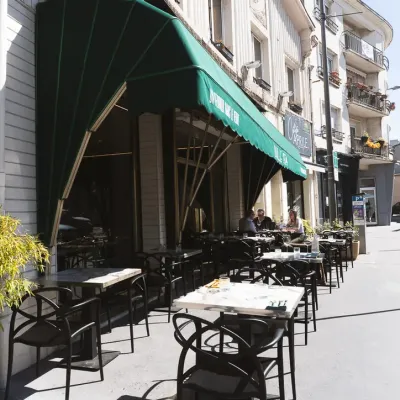 La terrasse de Bulle 1924 sur le trottoir, sous les stores verts