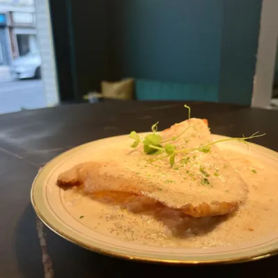 Aile de raie façon meunière servie dans une assiette à liseré doré